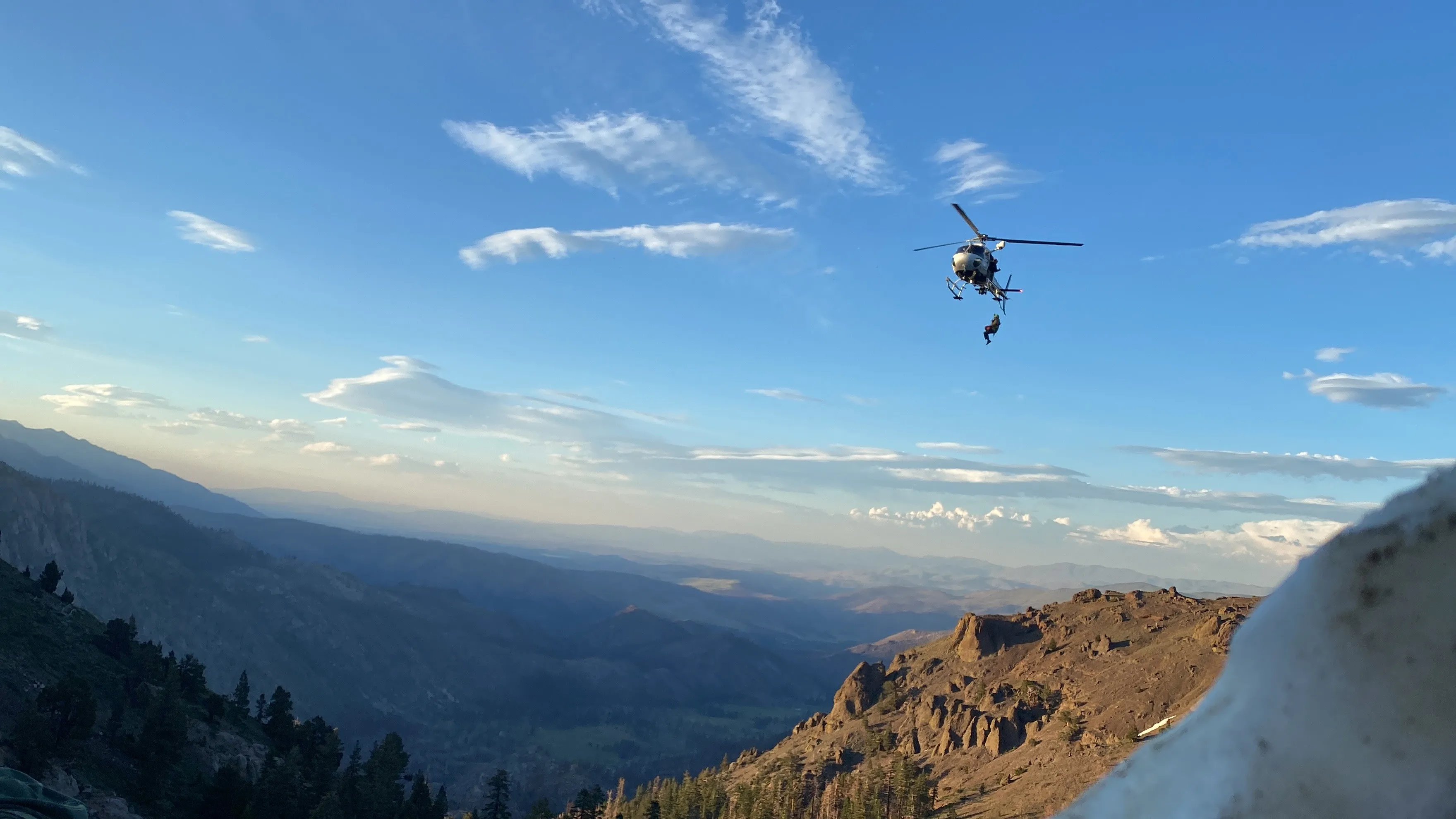 Helicopter flying over a Sierra ridgeline